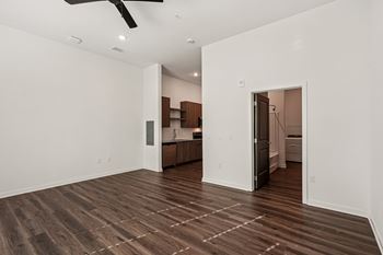 A room with a ceiling fan and wooden flooring